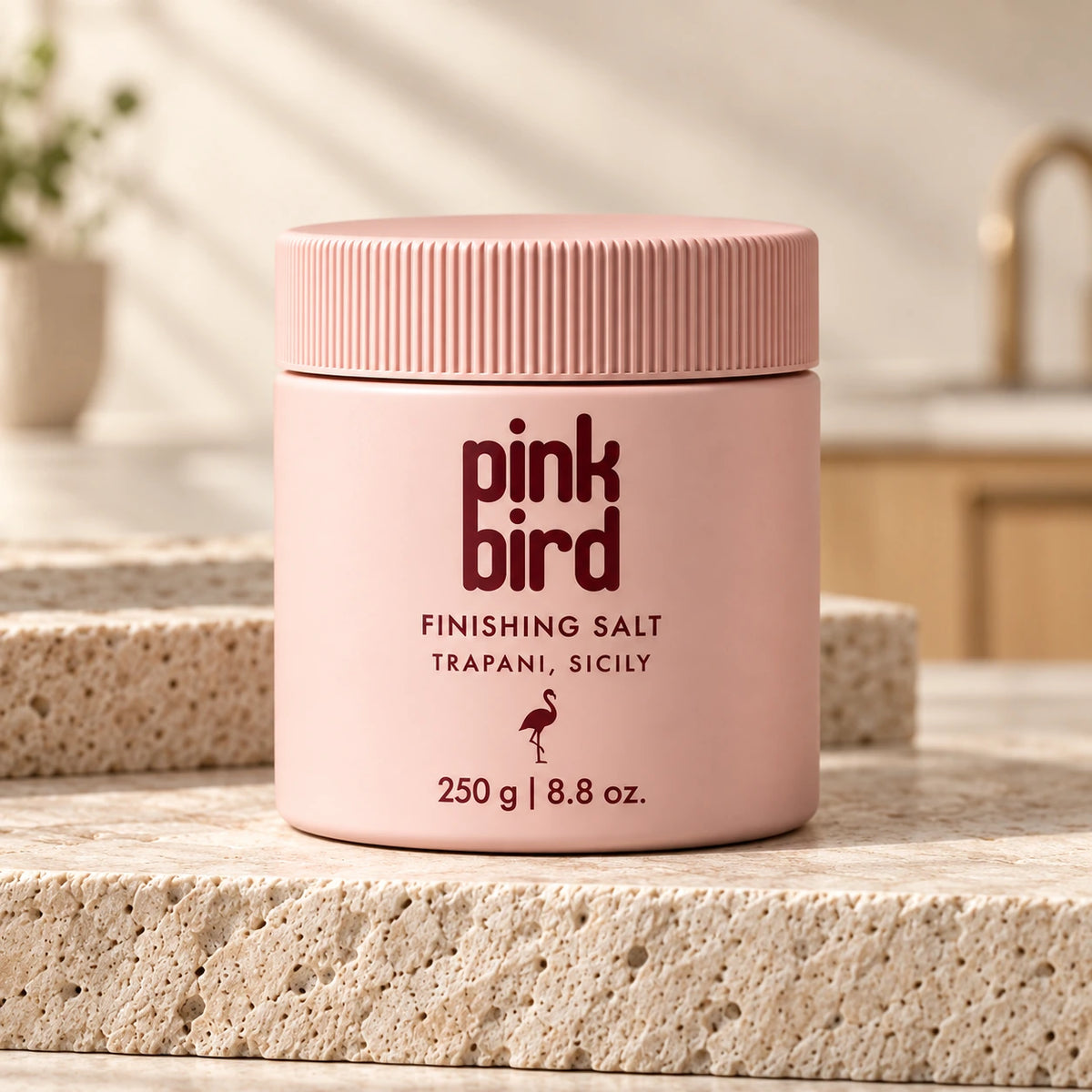 Pink Bird 250 g finishing salt jar on a travertine counter